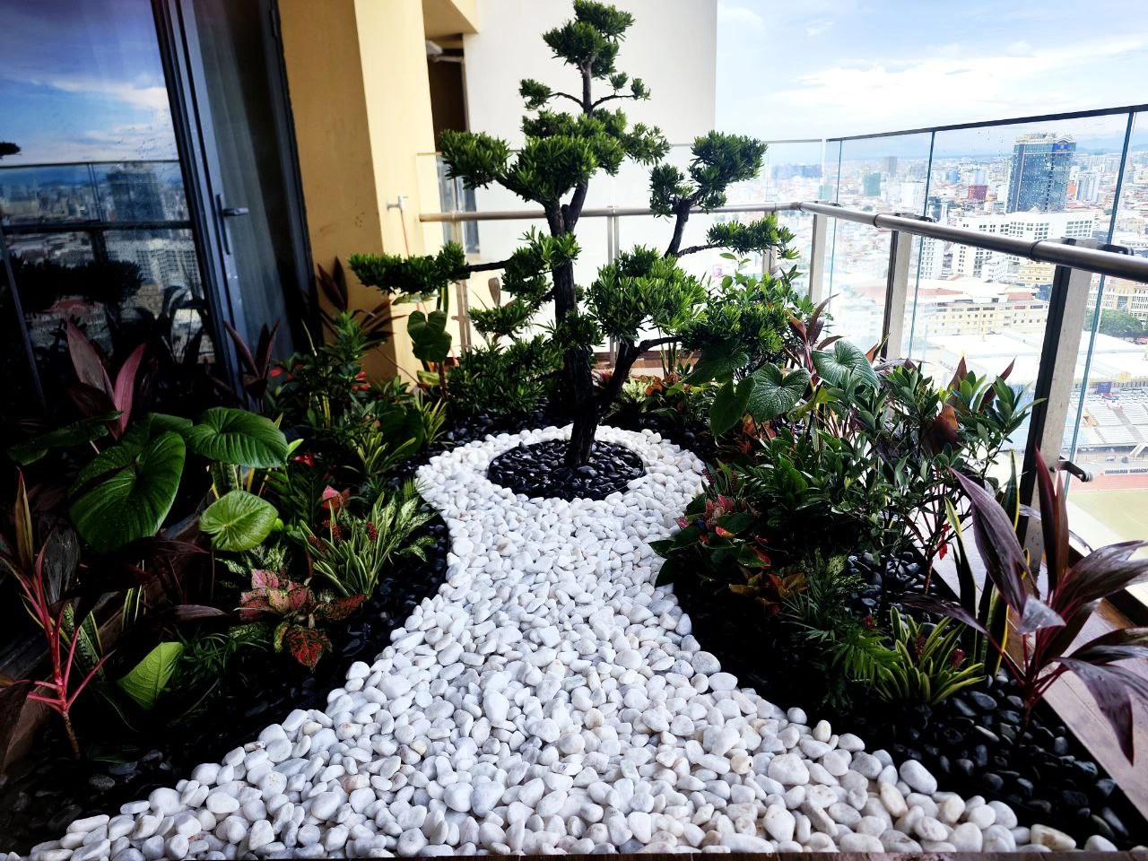 Zen-inspired balcony garden landscape design featuring a white pebble path and central bonsai